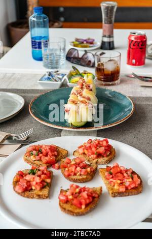 una tavola di cucina mediterranea con particolare attenzione al melone bianco servito con jamon serrano. Foto Stock