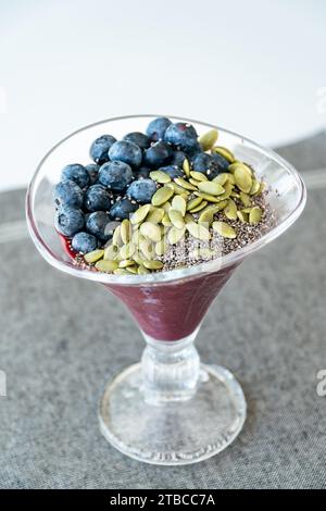 un'immagine ritratto di un bicchiere di gelato di acai condito con frutti di bosco e semi. Foto Stock