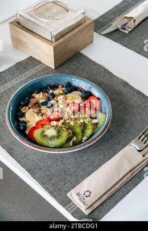 un'immagine ritratto di una ciotola di gelato all'acai condita con una selezione di frutta fresca Foto Stock