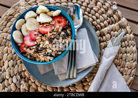 un'immagine a volo d'uccello di una ciotola di gelato all'acai condita con frutta fresca e avena in un ristorante mediterraneo Foto Stock