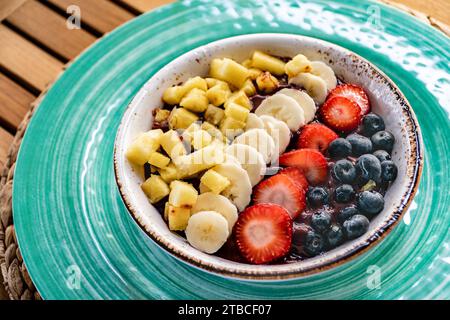 un'immagine ravvicinata di una ciotola di gelato all'acai condita con vari frutti e frutti di bosco Foto Stock