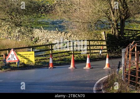 Traffico nel Regno Unito - 6 dicembre 2023 - il Consiglio di Bradford organizza il caos bloccato nel villaggio di Burley-in-Wharfedale. Due strade lasciano il villaggio per dirigersi verso ovest - la trafficata A65 che dovrà affrontare lavori stradali per i prossimi 7 mesi, in quanto uno sviluppo abitativo indesiderato è costruito su edifici verdi. Mentre gli abitanti del villaggio cominciavano ad adattarsi alla coda per questo, il consiglio di Bradford organizzò l'unica altra strada ad ovest, la strada della brughiera per Ilkley, ad essere chiusa. Il villaggio si è fermato stamattina. Ultimo: workman completato in 1 giorno e non 3. Burley-in-Wharfedale, Ilkley, West Yorkshire Inghilterra Regno Unito crediti: Rebecca Cole/Alamy Live News Foto Stock