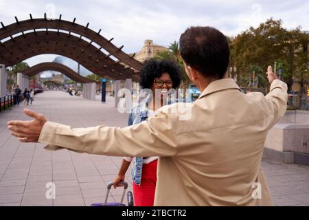 Incontro per strada di due persone che non si vedono da molto tempo, che stanno per abbracciarsi. Foto Stock