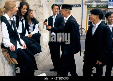 Studenti stranieri della Oxford University e della St Edmund Hall. Gli studenti dopo l'immatricolazione e indossano subfusc, che è un requisito per l'iscrizione formale in attesa di amici in Hight Street. La sua Freshers Week. Lo studente straniero di cinghiale mortaio è un giovane tedesco d'oltremare, Florian Seubert. Oxford, Oxfordshire, Inghilterra settembre 1990s 1995 UK HOMER SYKES Foto Stock