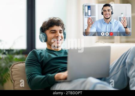 L'arabo effettua una videochiamata su un notebook che indossa gli auricolari in interni Foto Stock
