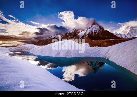 Riflesso del picco marmoreo nel lago glaciale nella catena montuosa del Karakorum Foto Stock