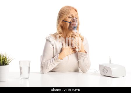 Donna che usa un nebulizzatore a un tavolo isolato su sfondo bianco Foto Stock