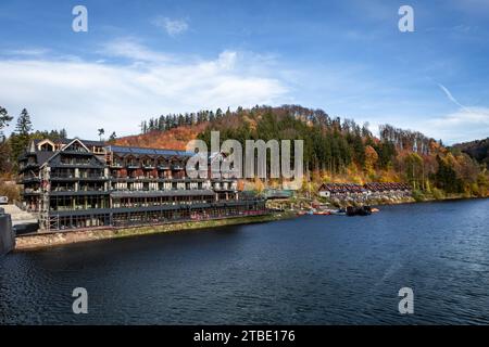 Zagorze Slaskie, Polonia - 9 novembre 2023: Paesaggio autunnale con lago Bystrzyckie e edificio alberghiero Maria Antonina. Foto Stock