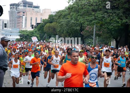 I partecipanti entusiasti percorrono la vivace corsa su strada di Saint Silvester a São Paolo, Brasile, tracciando il loro percorso lungo l'iconica Avenida con Foto Stock