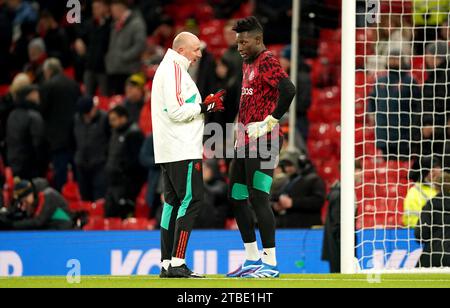 Il portiere del Manchester United Andre Onana con l'allenatore di portieri Richard Hartis prima della partita di Premier League all'Old Trafford, Manchester. Data foto: Mercoledì 6 dicembre 2023. Foto Stock