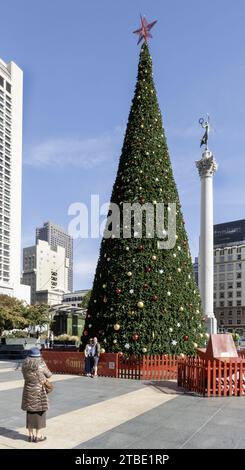 La gente posa per una foto di fronte all'albero di Natale di Macy's a Union Square, San Francisco, California, USA Foto Stock