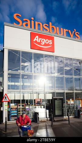 Un vecchio acquirente che lascia il superstore Sainsbury's a Scarborough Foto Stock