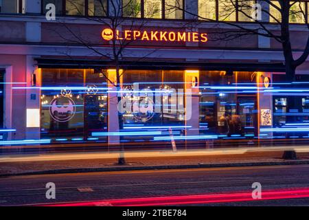 Lepakkomies dive bar e luogo di musica dopo il tramonto con strisce luminose di veicoli di emergenza nel quartiere Harju di Helsinki, Finlandia Foto Stock