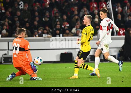 Stoccarda, Germania. 6 dicembre 2023. Calcio: DFB Cup, VfB Stoccarda - Borussia Dortmund, round of 16, MHPArena. Il portiere di Stoccarda Alexander Nübel (l) ferma un tentativo di gol da parte del Dortmund Marco Reus (M). NOTA IMPORTANTE: In conformità alle norme della DFL German Football League e della DFB German Football Association, è vietato utilizzare o far utilizzare fotografie scattate nello stadio e/o della partita sotto forma di immagini sequenziali e/o di serie di foto simili a video. Credito: Tom Weller/dpa/Alamy Live News Foto Stock