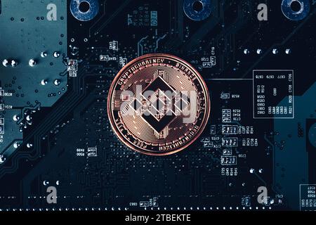 Moneta token di criptovaluta BNB Binance sullo sfondo della scheda a circuiti stampati Foto Stock