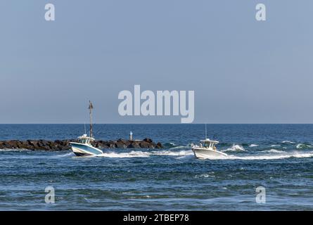 due piccole imbarcazioni elettriche che arrivano in un'insenatura di hamptons bay Foto Stock