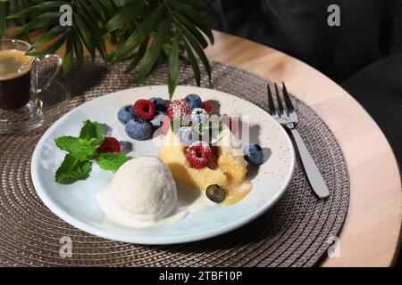 Delizioso fondente alla vaniglia servito con gelato e frutti di bosco sul tavolo Foto Stock