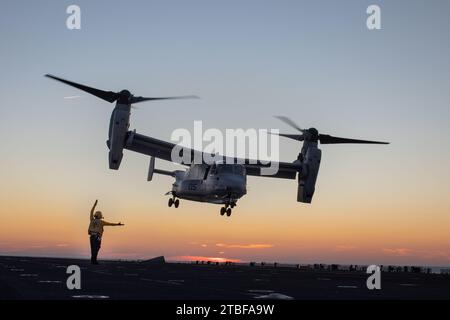 North Carolina, Stati Uniti. 21 ottobre 2021. Un marinaio della Marina degli Stati Uniti assegnato alla nave d'assalto anfibio USS Kearsarge (LHD 3) dirige l'atterraggio di un MV-22 Osprey assegnato al Marine Medium Tiltrotor Squadron (VMM) 263, durante le operazioni di volo a bordo della nave d'assalto anfibio USS Kearsarge (LHD 3), 'Octoberober 20, 2021. Il VMM-263 è l'elemento di combattimento aereo della 22nd Marine Expeditionary Unit. Kearsarge, l'ammiraglia del 22° MEU e dello Squadrone anfibio (PHIBRON) 6, è in corso per la formazione integrata PHIBRON-MEU (PMINT) in preparazione di un futuro impiego. PMINT è il primo periodo in mare Foto Stock