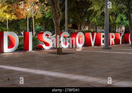 Lettere 3d tridimensionali rosse e grigie che formano la parola DISCOVERY con uno sfondo serale all'aperto. Foto Stock