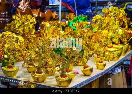 Molte decorazioni come simbolo di ricchezza nel mercato per il Tet Lunar New Year con testo tradotto come "Happy New Year" in vietnamita Foto Stock