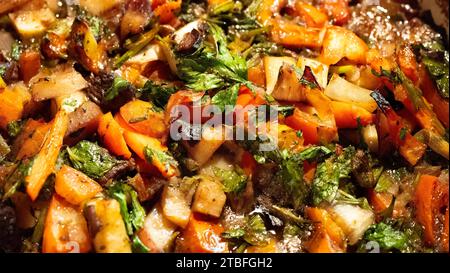 Abbondante stufato di manzo e verdure da vicino. Full frame, colori autunnali, arancione, verde, marrone; gustoso pasto caldo. Scatto dall'alto, messa a fuoco selettiva. Foto Stock