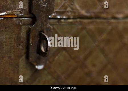 Lucchetto in ferro con scatola marrone orizzontale. Lucchetto in ferro dorato che blocca una scatola di legno marrone. Foto Stock