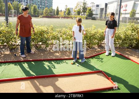 Bambini informali in un campo da golf con mazze da golf. Foto Stock