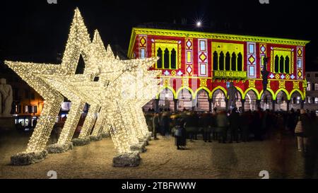 Decorazioni natalizie e illuminazione su una piazza italiana. La Loggia del Lionello decorata con luci colorate. Udine, Friuli Venezia Giulia. Foto Stock