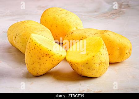 Un primo piano di patate, intere e affettate, su un ripiano Foto Stock