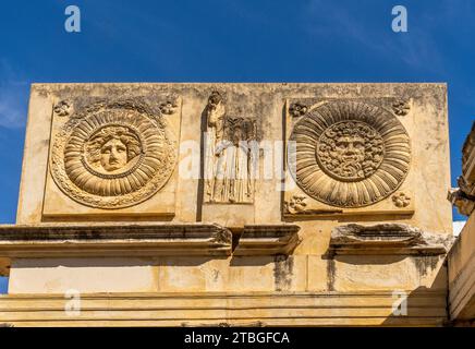 Particolare frontale della facciata del portico monumentale con bassorilievi e medaglioni con metope dell'antico foro Comunale di Augusta Emerita di M Foto Stock