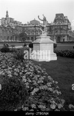 Eine Skulptur im Tuileriengarten, vermutlich Dionysos darstellend, nahe der heutigen Place du Carousel mit dem Louvre im Hintergrund, Parigi 1962. Una scultura nel Giardino delle Tuileries, probabilmente rappresentante Dioniso, vicino all'attuale Place du Carousel con il Louvre sullo sfondo, Parigi 1962. Foto Stock