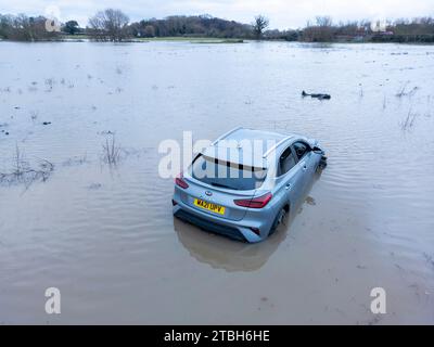 Un'auto esce dalla Old Holly Lane per entrare nei campi allagati vicino ad Atherstone. Il fiume Anker fa scoppiare le sue rive inondando i campi lungo la Sheepy Road sul confine del Warwickshire, Leicestershire. Foto Stock