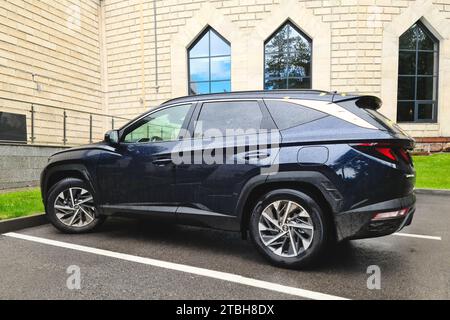 Un incrocio blu Hyundai Tucson a quattro ruote motrici è parcheggiato vicino all'edificio Foto Stock