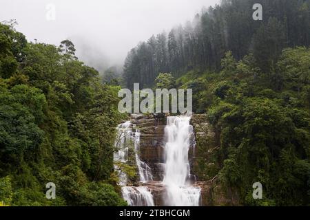 Alta cascata piena di acqua in mezzo alla natura. Ramboda cade nei pressi di Nuwara Eliya in Sri Lanka. Foto Stock