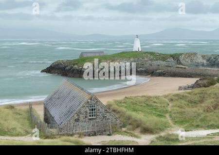 Il faro di Bach TWR e la vecchia stazione di imbarcazioni di salvataggio sull'isola di Llanddwyn, al largo della costa di Anglesey, Galles, Regno Unito. Autunno (ottobre) 2023. Foto Stock