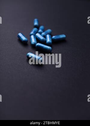 Capsule di aminoacidi su sfondo di carta scura. Messa a fuoco morbida. Primo piano. Copia spazio. Foto Stock