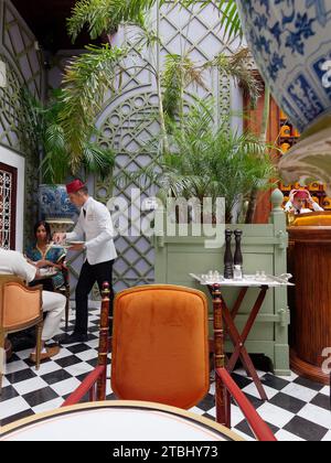 Bacha Coffee Cafe all'interno del Palazzo Dar el Bacha. Il membro del personale con cappello di Fez serve i clienti. Marrakech, alias Marrakech, Marocco, 7 dicembre 2023 Foto Stock