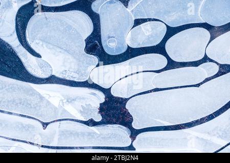 Pozzanghere ghiacciate durante una passeggiata mattutina invernale Foto Stock