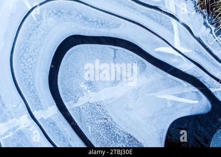 Pozzanghere ghiacciate durante una passeggiata mattutina invernale Foto Stock