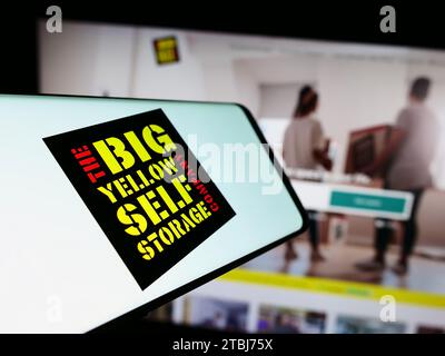 Telefono cellulare con logo della società britannica Big Yellow Group plc, di fronte al sito Web aziendale. Concentrarsi sul centro del display del telefono. Foto Stock