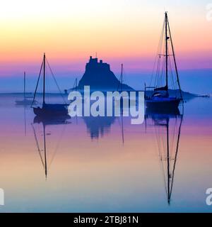 Alba in estate sulla Holy Island di Lindisfarne guardando dal porto verso Lindisfarne Castle, Northumberland, Inghilterra Foto Stock