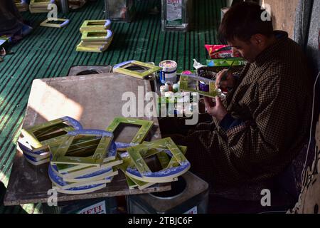 Un artigiano Kashmiri effettua i ritocchi finali su un prodotto in cartapesta prima di inviarlo al mercato in un laboratorio. La cartapesta secolare, una forma d'arte profondamente intrecciata con la cultura e le tradizioni della società Kashmiri, sta morendo lentamente, poiché il numero di persone coinvolte nel commercio è diminuito per varie ragioni. Migliaia di famiglie in Kashmir si guadagnarono da vivere vendendo e facendo oggetti di cartapesta. L'emergere dell'arte della cartapesta accompagnò l'avvento dell'Islam nella regione. Fu introdotto in Kashmir dallo studioso sufi Mir Sayyid Ali Hamdani Foto Stock