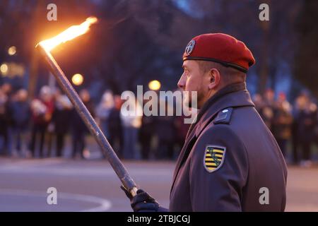 Gera, Germania. 7 dicembre 2023. Un soldato della Bundeswehr sta con una torcia in mano alla cerimonia pubblica di giuramento per circa 100 reclute della quinta compagnia del battaglione di ingegneri corazzati 701 nel parcheggio di Hofwiesen. Credito: Bodo Schackow/dpa/Alamy Live News Foto Stock