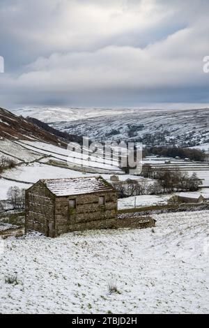 Fienili innevati a Swaledale, vicino a Thwaite, in un giorno d'inverno. Yorkshire Dales National Park, Regno Unito. Foto Stock