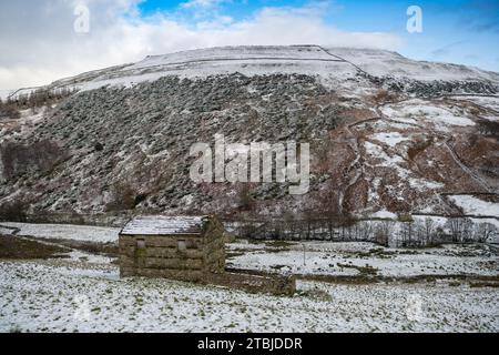 Fienili innevati a Swaledale, vicino a Thwaite, in un giorno d'inverno. Yorkshire Dales National Park, Regno Unito. Foto Stock