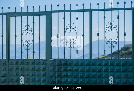 Porta Metal Green vicino alla splendida tenuta nelle giornate di sole di Saranda Albania. Cancello in stile vittoriano. Lavori in metallo Foto Stock