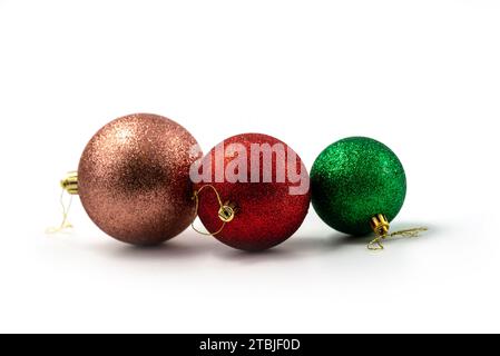 Tre palline di Natale (sfere), rosa, rossa e verde isolate su bianco Foto Stock