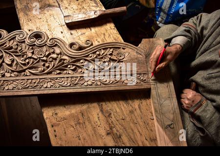 Srinagar, India. 7 dicembre 2023. Un artigiano Kashmiri intaglia un oggetto artigianale in una fabbrica di intaglio del legno. Il Kashmir, il paradiso sulla terra, si riferisce alla bellezza naturale mozzafiato della regione e all'artigianato tradizionale. Insieme a molti altri tipi di arte, il Kashmir è rinomato per la sua tecnica unica di intaglio del legno. L'intaglio in legno Kashmiri è molto richiesto sia all'interno che all'esterno dello stato. Il suo mercato è cresciuto sia a livello locale che globale nel corso degli anni. Ma al giorno d'oggi, gli artigiani stanno lottando per mantenere viva questa arte. La maggior parte dei prodotti realizzati da questi artigiani non ottiene abbastanza profitti, a causa di Foto Stock