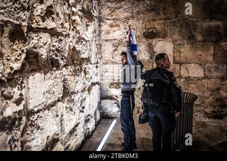 Gerusalemme, Israele. 7 dicembre 2023. Un ufficiale di polizia arresta un manifestante di estrema destra israeliano durante una marcia attraverso la città vecchia di Gerusalemme. Crediti: Ilia Yefimovich/dpa/Alamy Live News Foto Stock