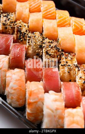 Ampia scelta di panini sushi con gamberi, salmone, tonno, anguilla, primo piano. Consegna di sushi. Foto Stock